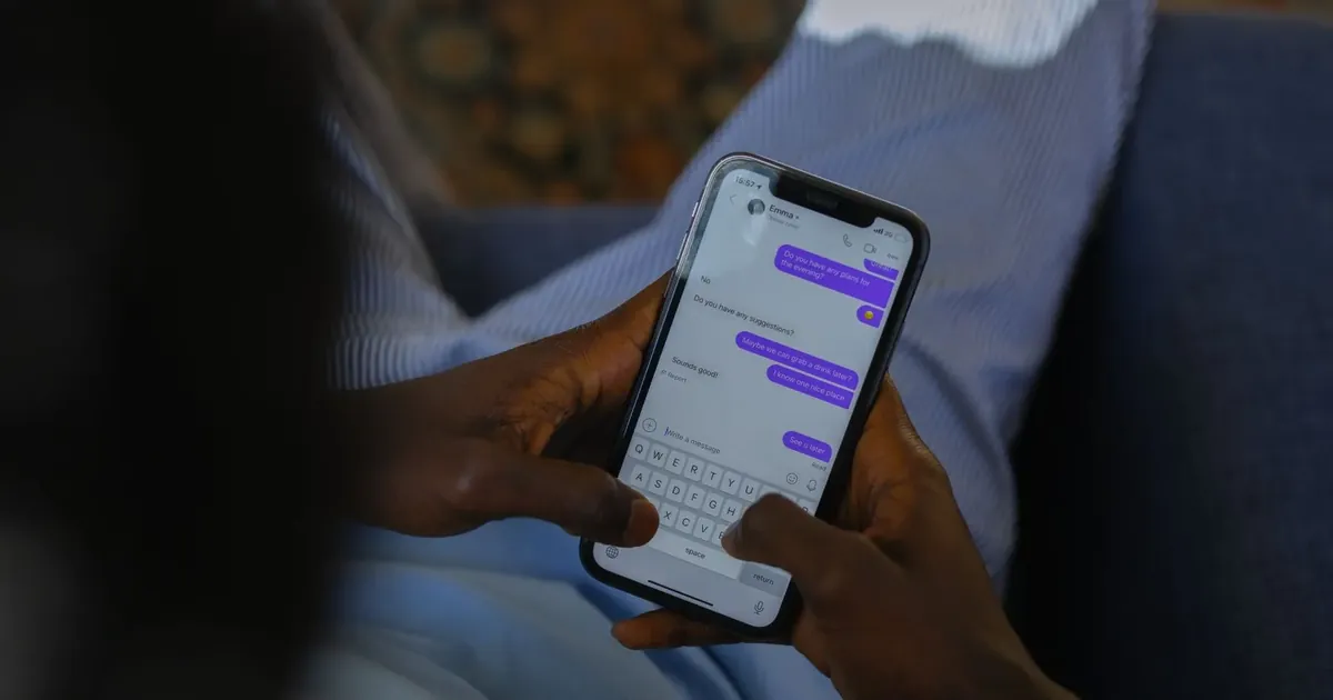 Ruka drží telefon s otevřenými textovými zprávami