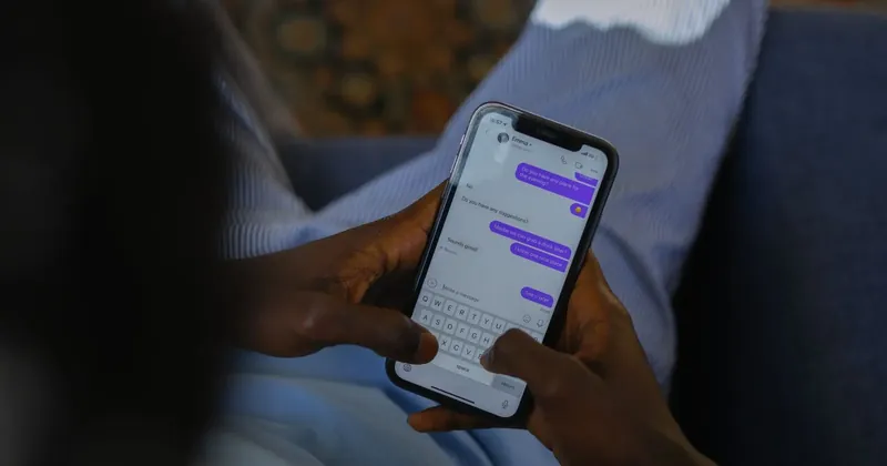 Ruka drží telefon s otevřenými textovými zprávami