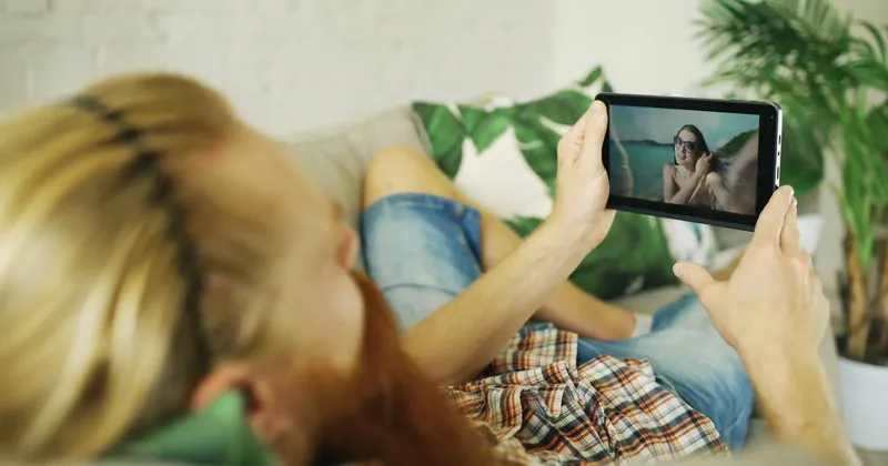 Žena sleduje video v mobilu