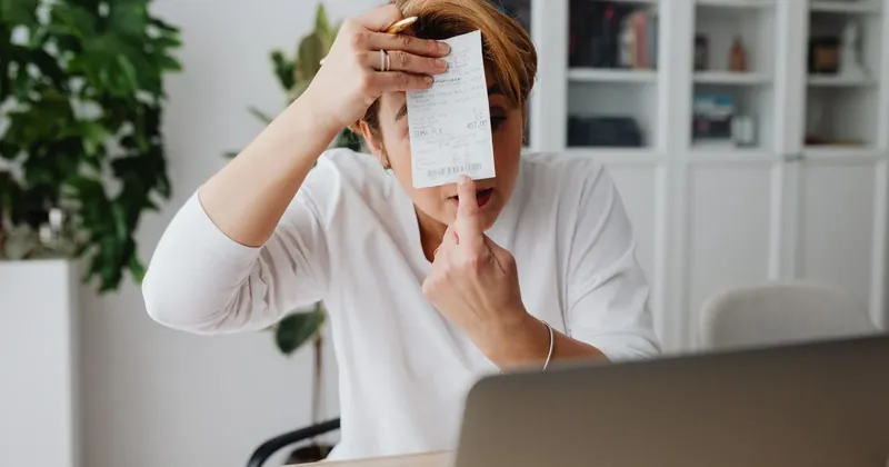 Žena se znepokojeně dívá na účet u notebooku