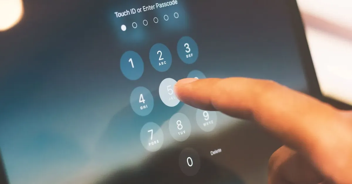 Prst zadává kód na číselné klávesnici telefonu