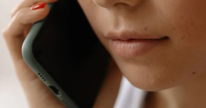 Žena drží mobilní telefon u ucha