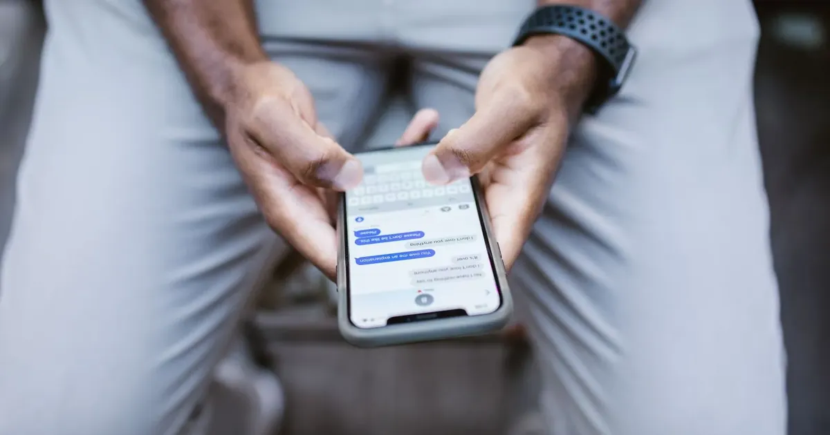 Muž čte textovou zprávu v mobilu