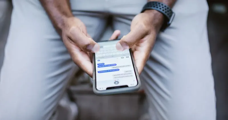 Muž čte textovou zprávu v mobilu
