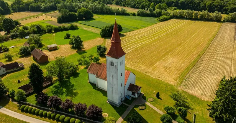 Malá obec s kostelem uprostřed polí
