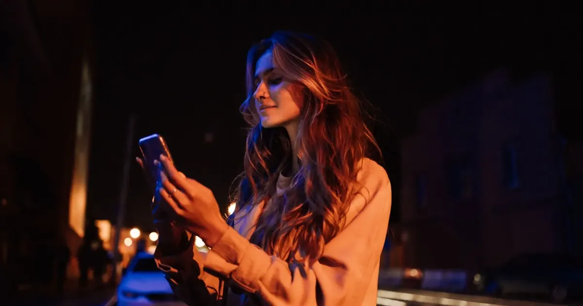 Žena v noci píše správy v mobile