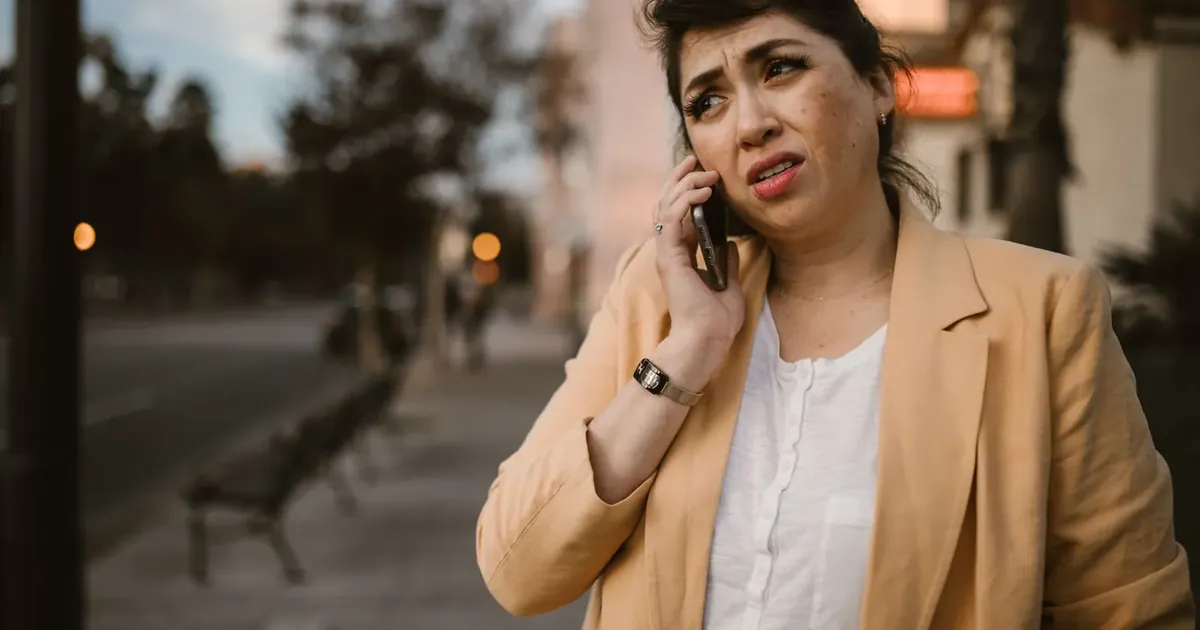 Žena na ulici nedůvěřivě telefonuje