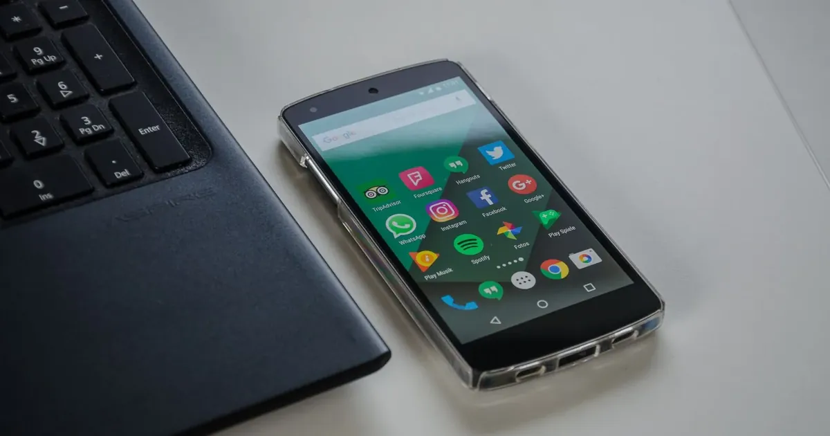 Telefon s Androidem a aplikacemi vedle klávesnice