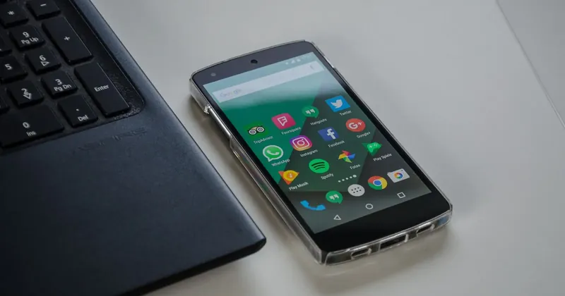 Telefon s Androidem a aplikacemi vedle klávesnice