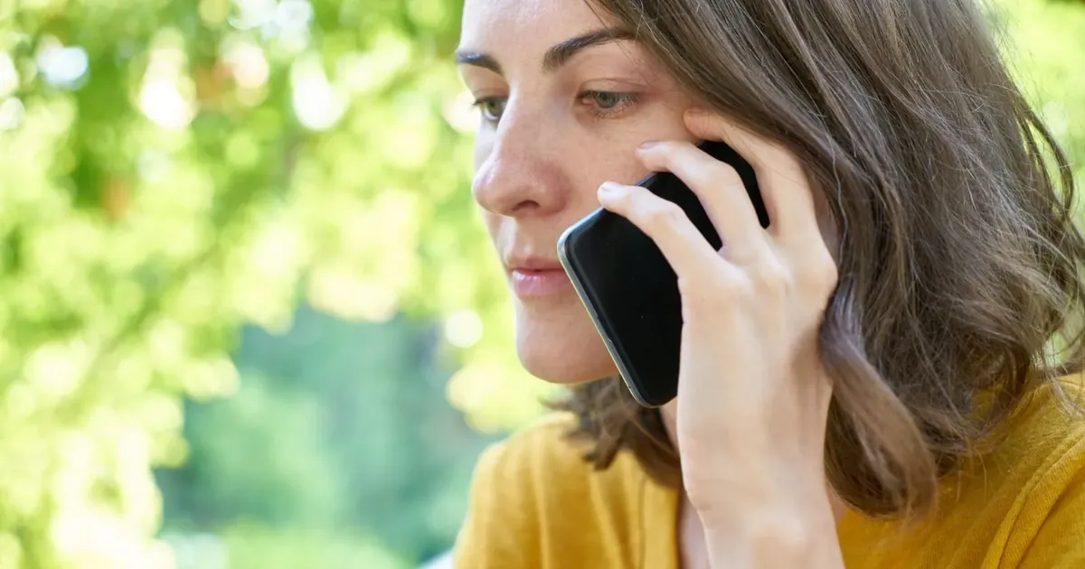 Žena soustředěně telefonuje