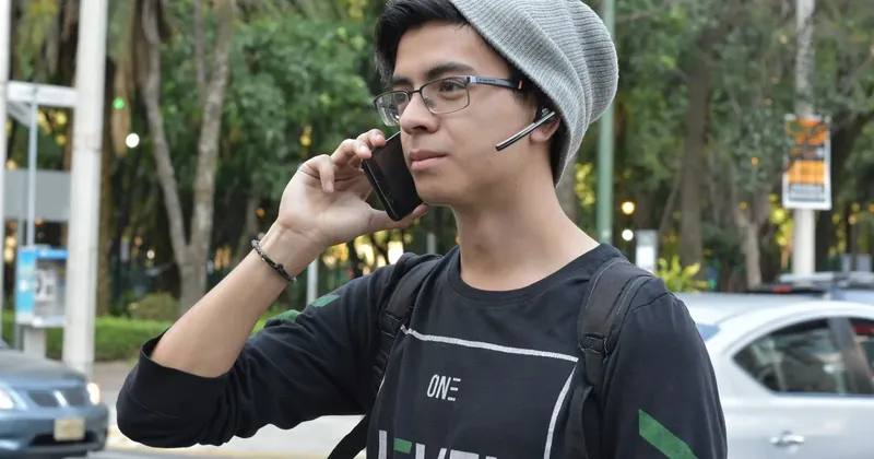 Mladý muž telefonuje na ulici