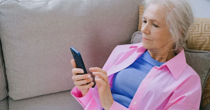 Starší žena používá aplikaci v mobilu