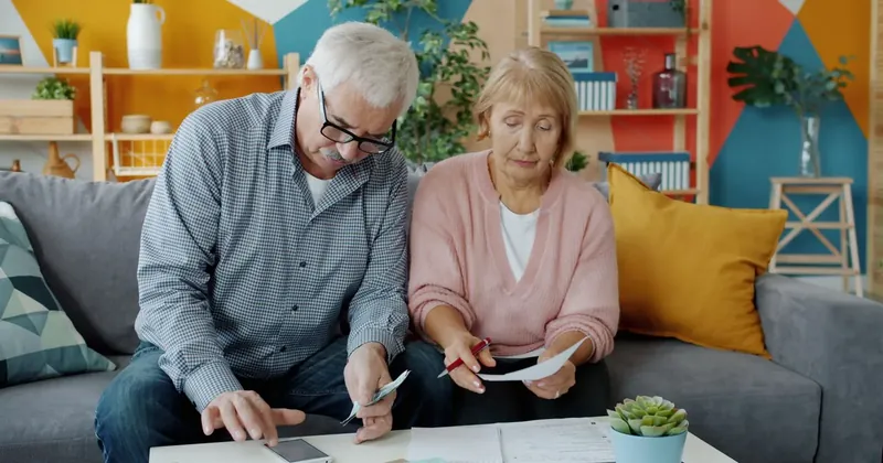 Starší manželé spolu procházejí úřední dopisy