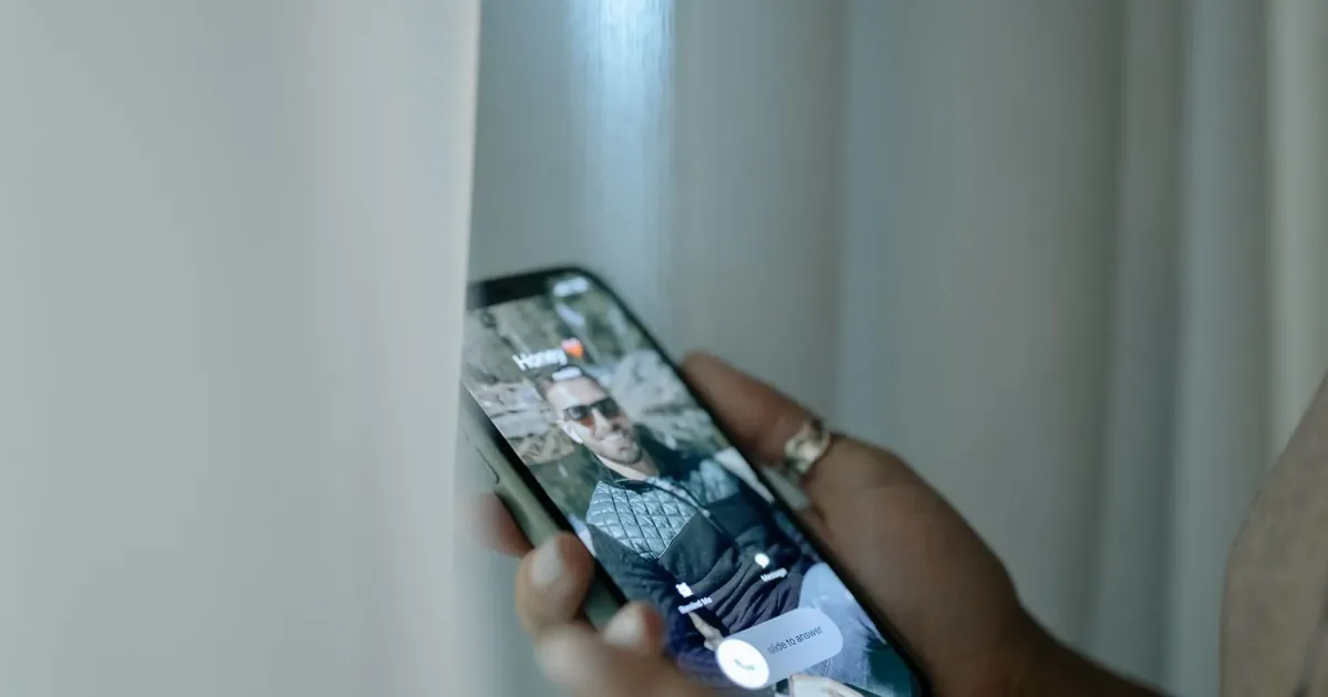 Muž drží telefon s probíhajícím hovorem