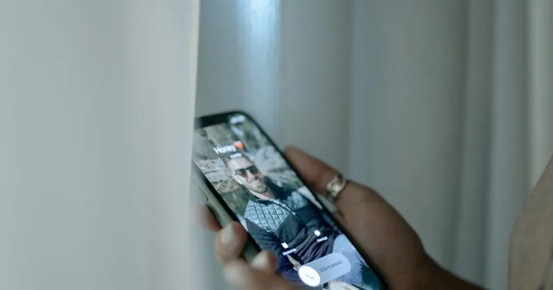 Muž drží telefon s probíhajícím hovorem