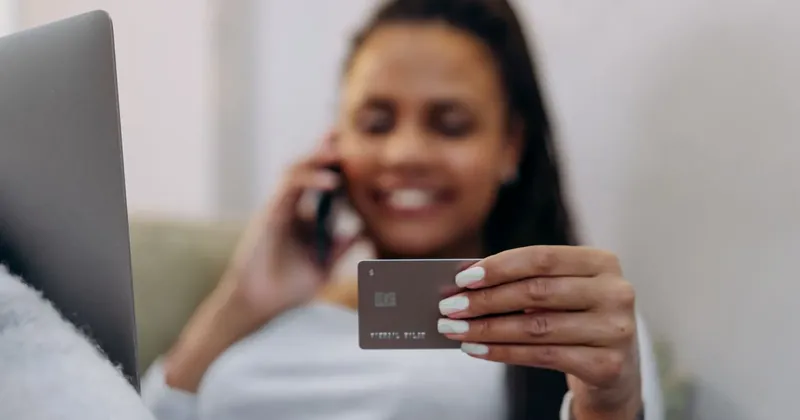 Žena telefonuje s platební kartou v ruce