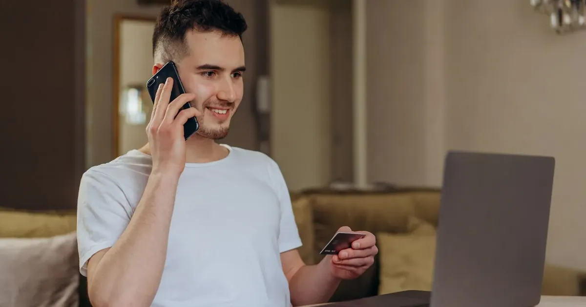 Muž telefonuje s platobnou kartou v ruke