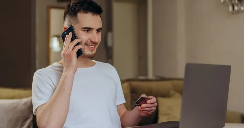Muž telefonuje s platobnou kartou v ruke