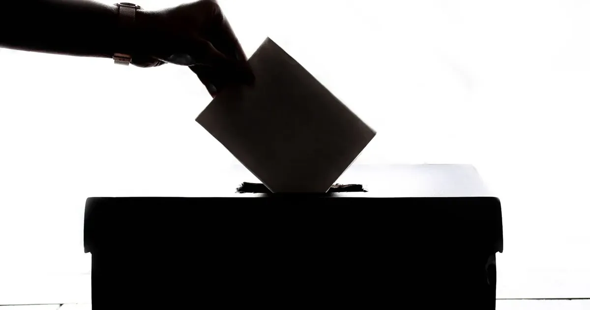 Vhazování obálky do volební urny
