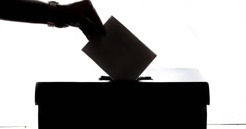 Vhazování obálky do volební urny
